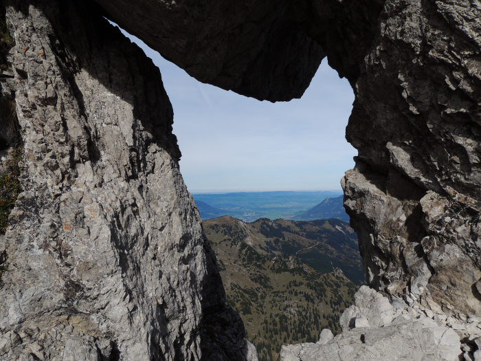 Felsloch am Klettersteig mit Blick auf das Voralpenland